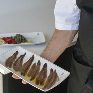 Un chef presenta un plato de anchoas de la Escala en el restaurante del Parador de Aiguablava
