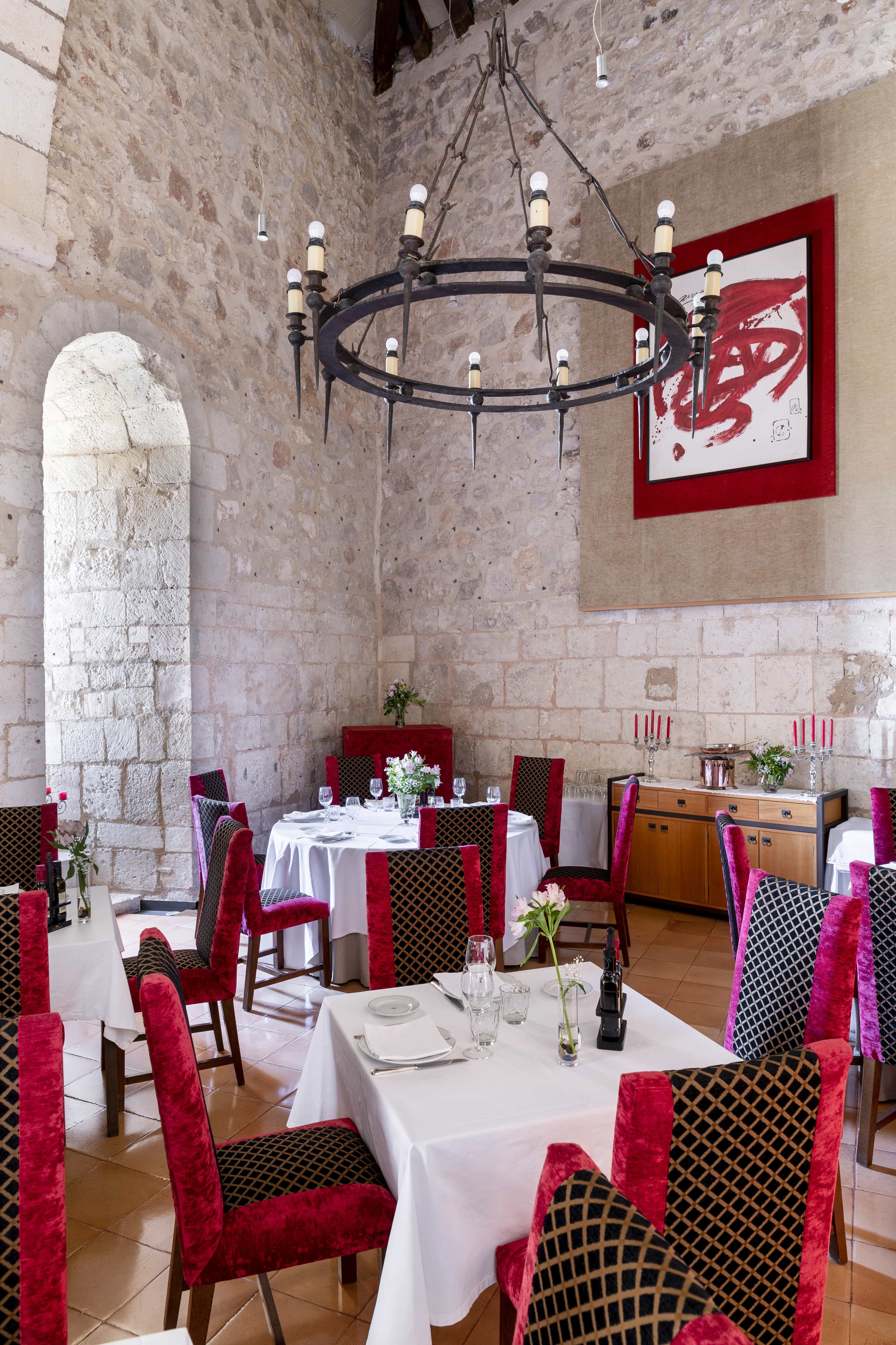 Comedor interior de piedra con butacas de terciopelo rojo del Restaurante del Parador de Alarcón