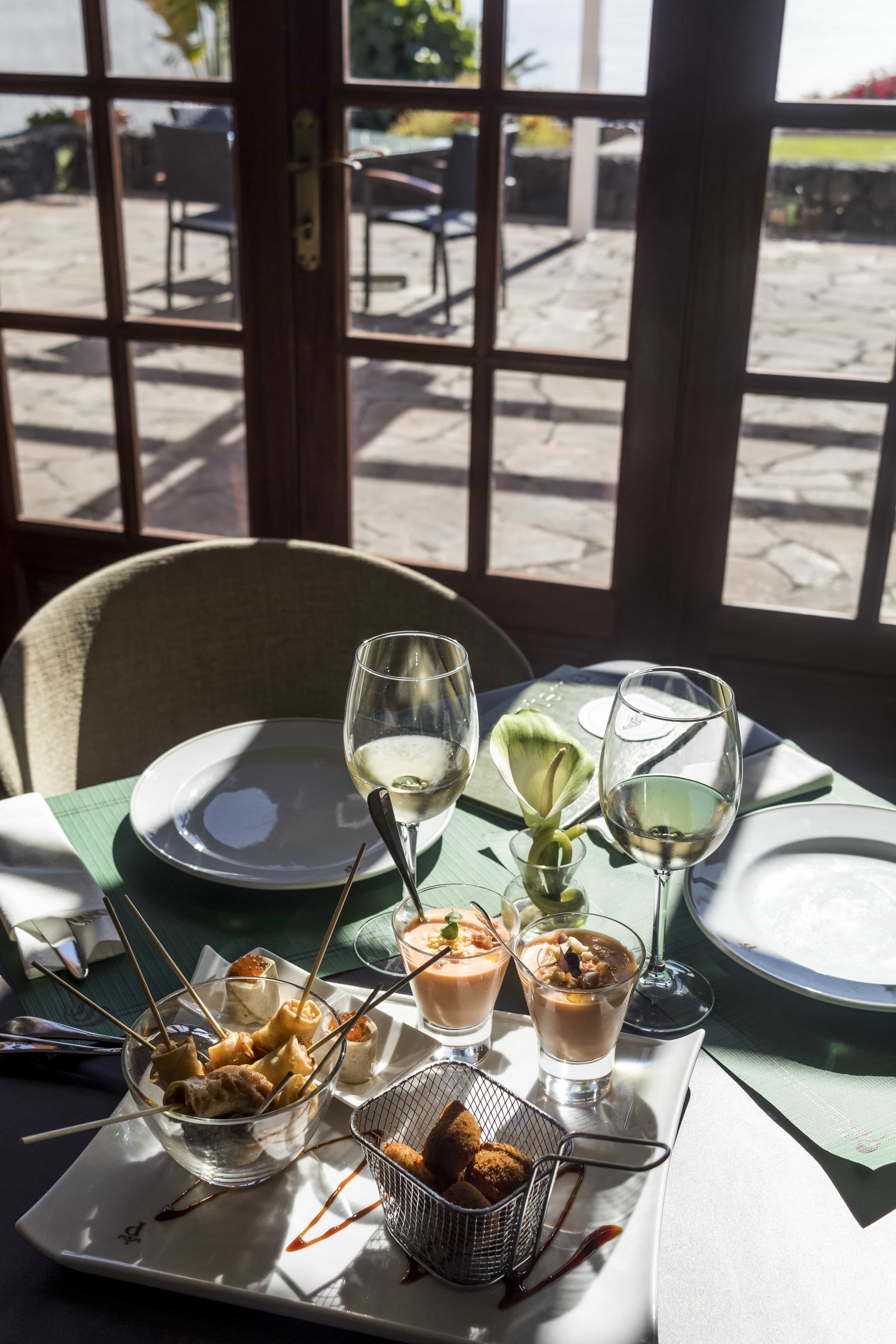 Aperitivos servidos en mesa con vistas a la terraza en el restaurante del Parador de La Palma