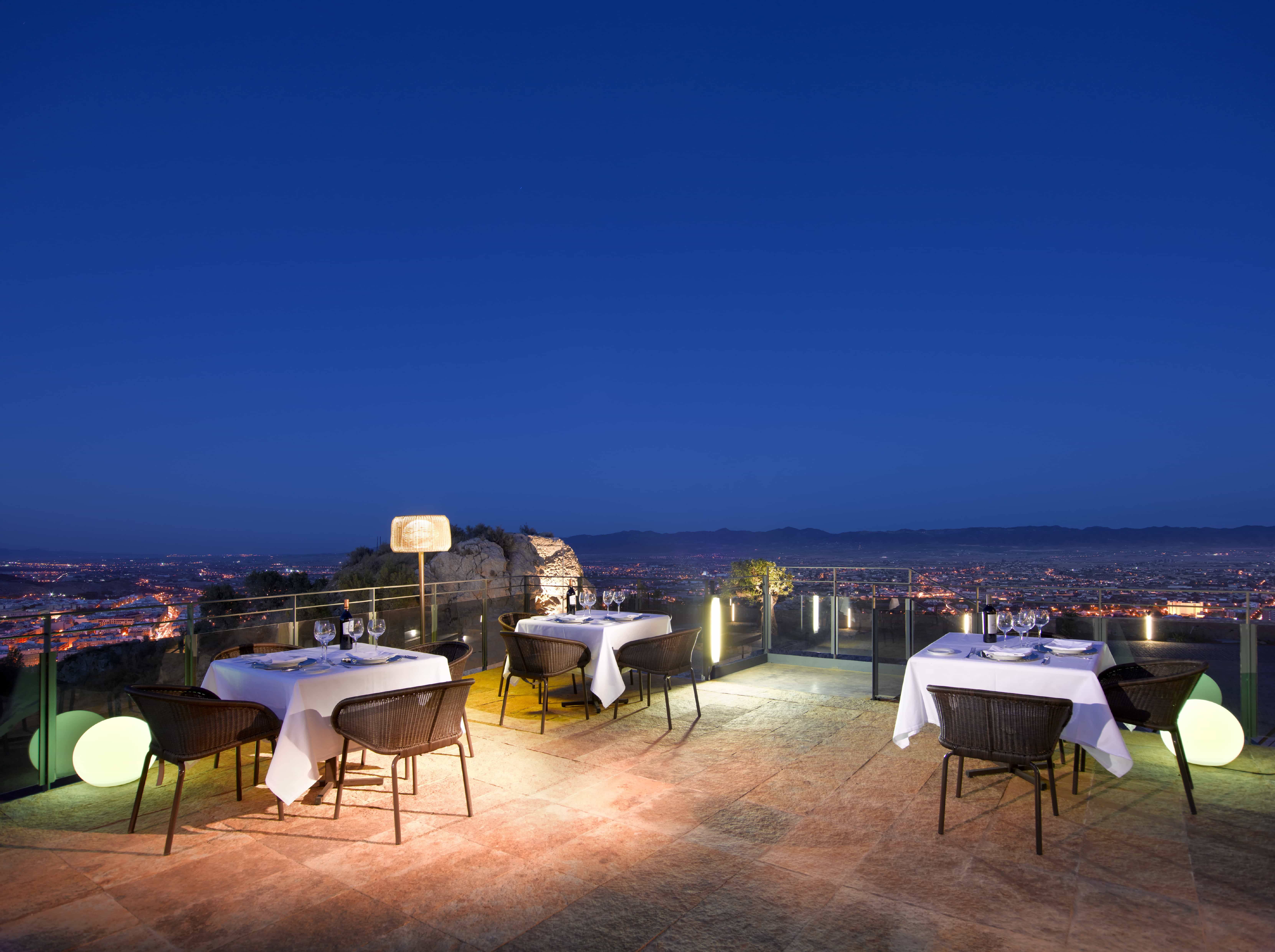 Vista nocturna de la terraza del Restaurante Helios del Parador de Lorca con la ciudad al fondo