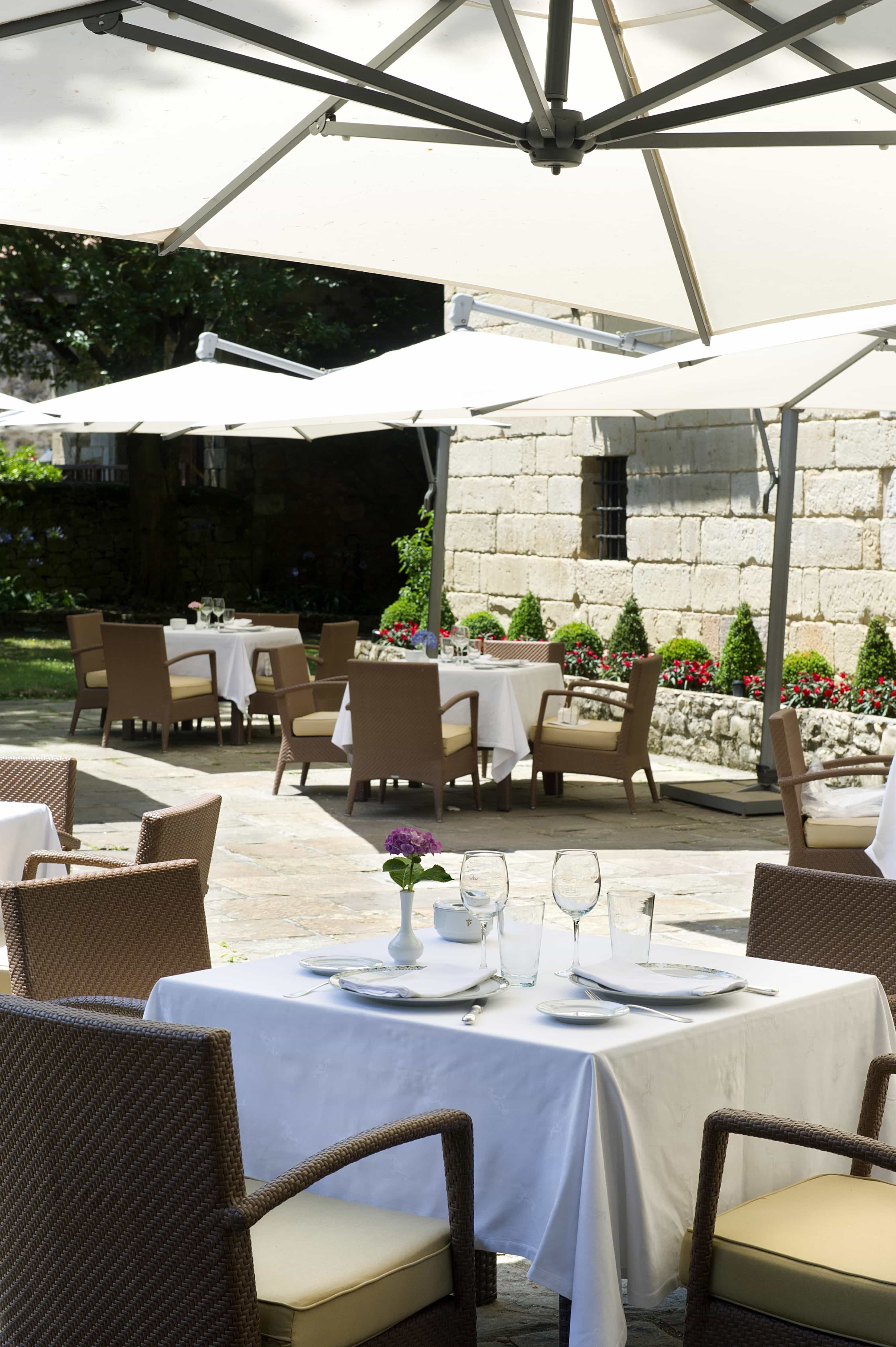 Terraza exterior con sombrillas del Restaurante El Jardín de Gil Blas del Parador de Santillana Gil Blas