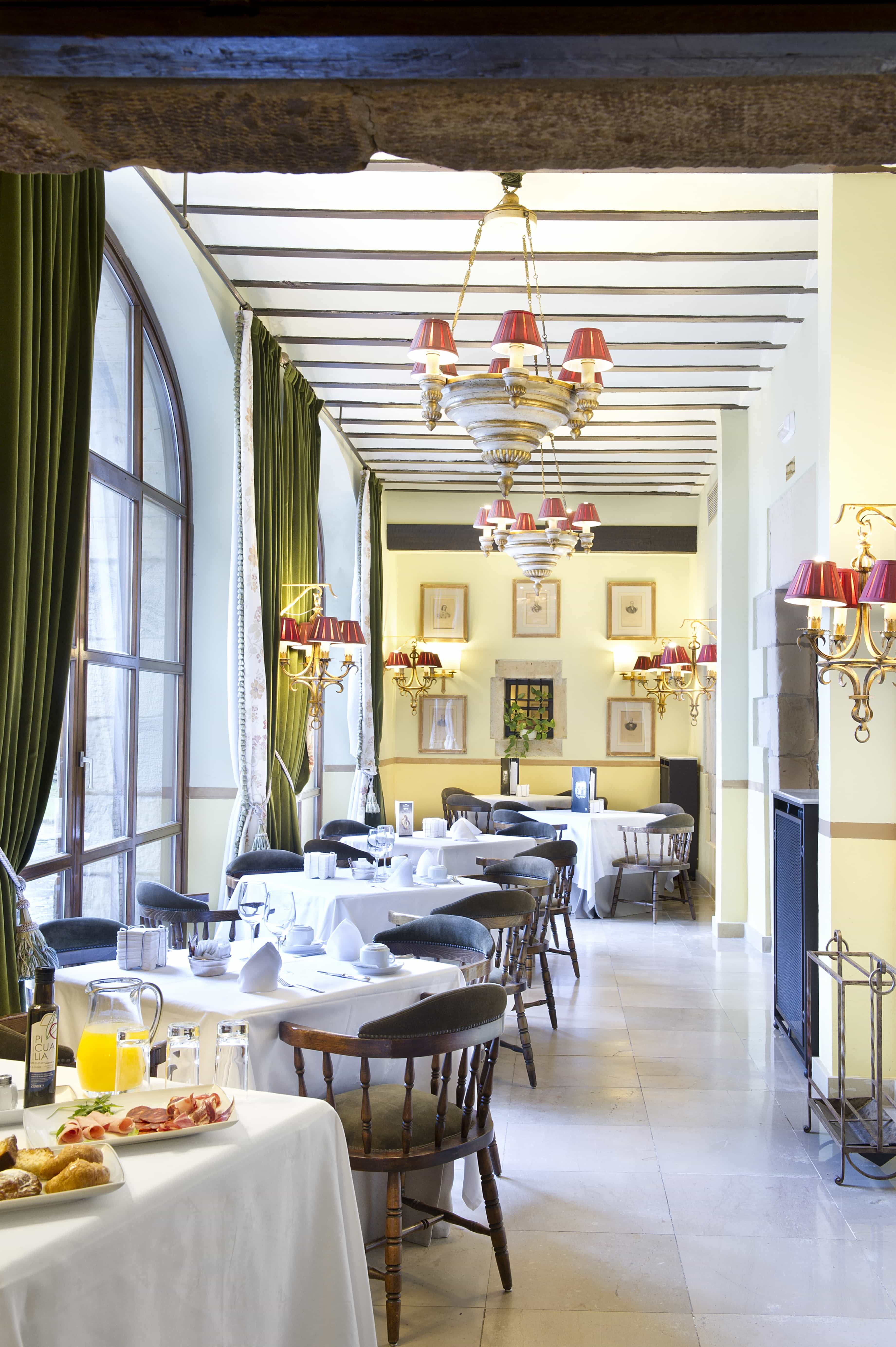 Mesas iluminadas por la galería del Restaurante del Parador de Santillana del Mar