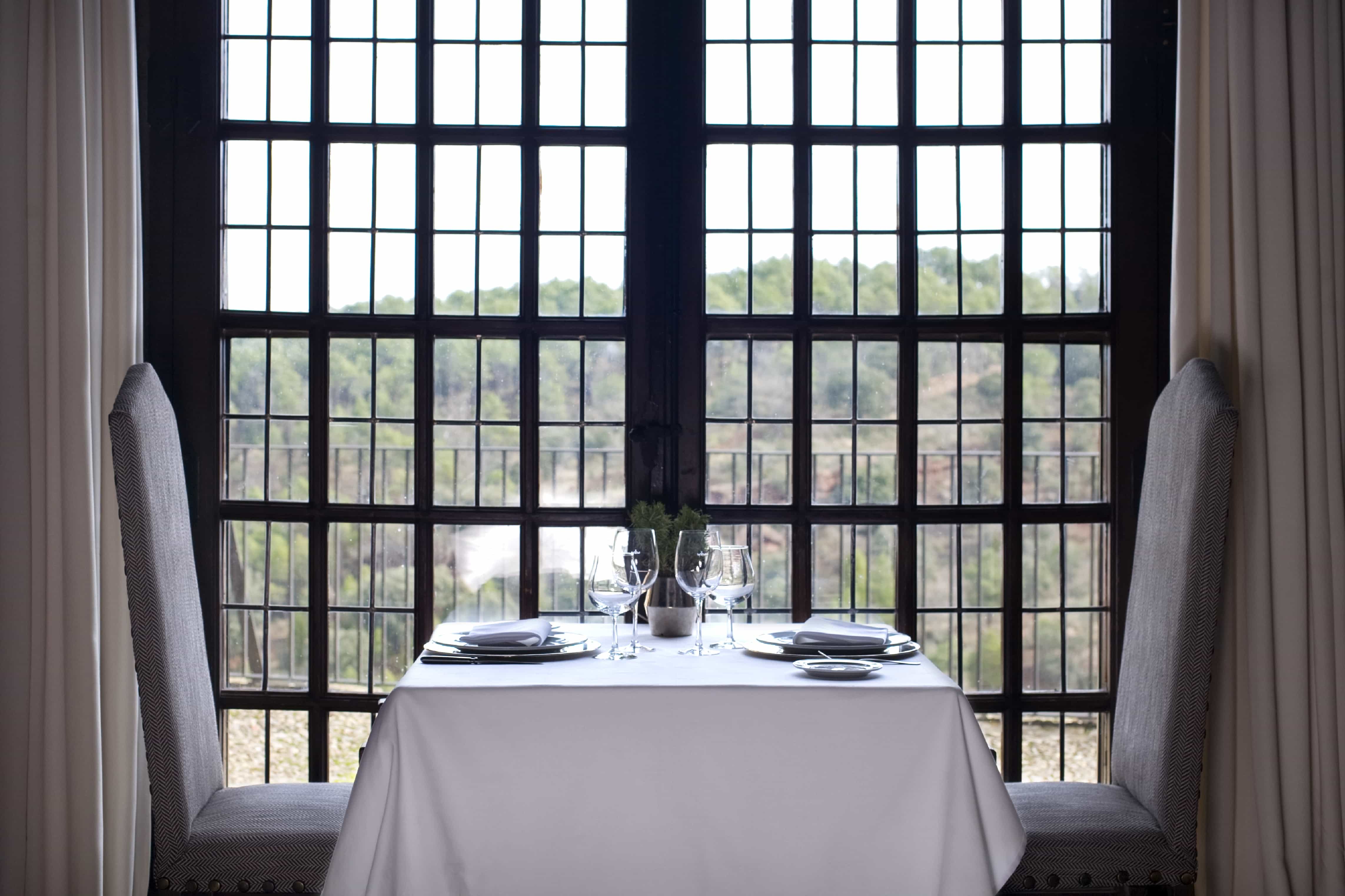 Mesa para dos preparada junto a ventana del comedor del Restaurante del Parador de Sigüenza