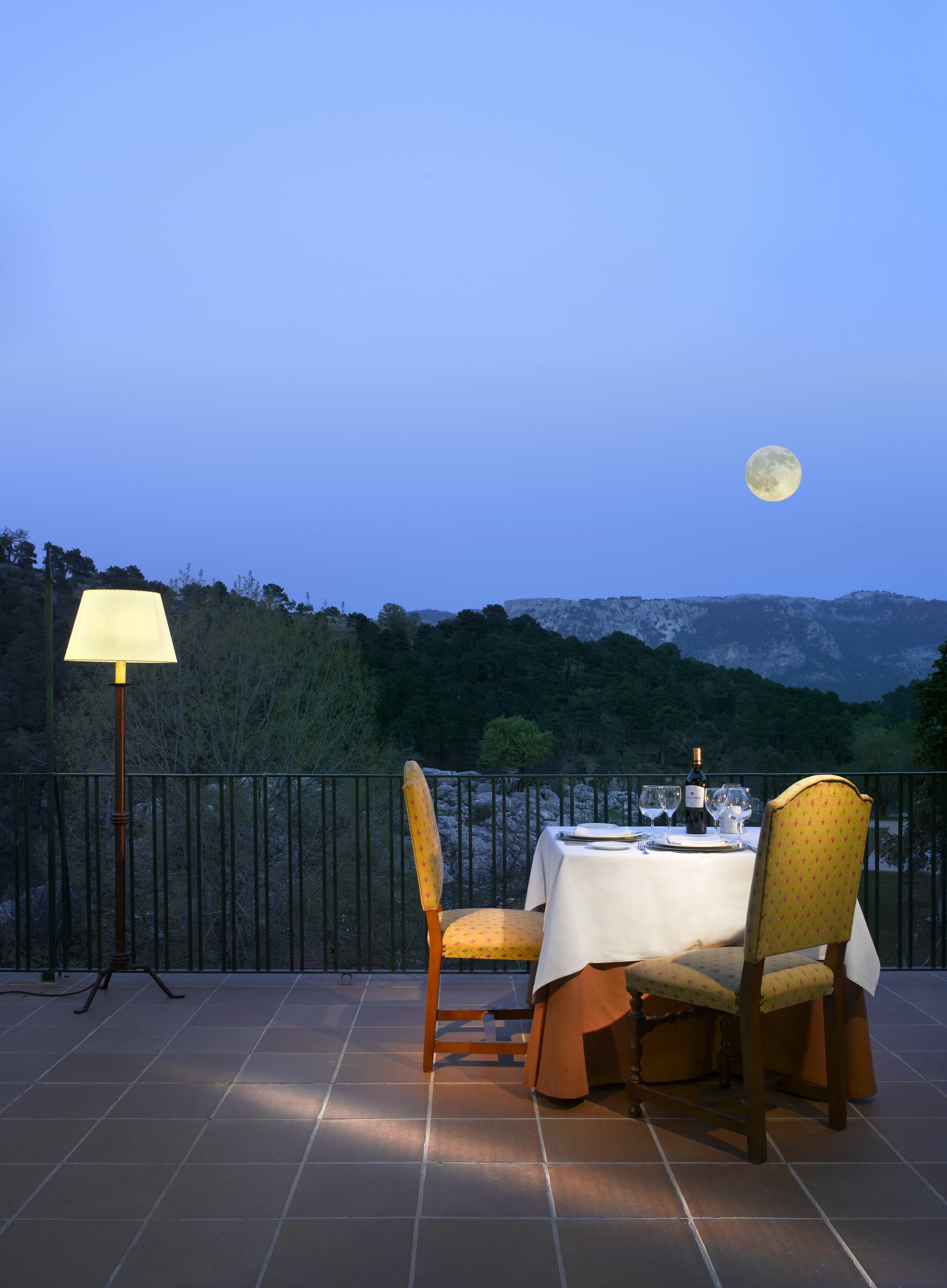Vista de la terraza del Restaurante Parador de Cazorla anocheciendo con la luna sobre el Parque Natural