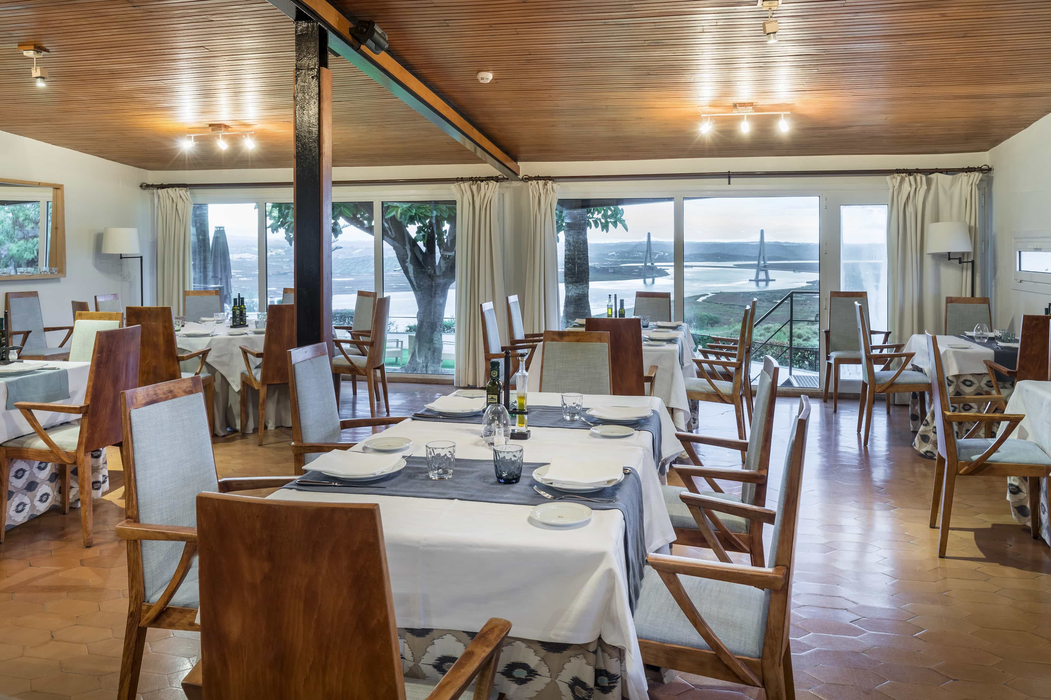 Comedor del Restaurante del Parador de Ayamonte con mesas preparadas y vistas a la desembocadura del Guadiana