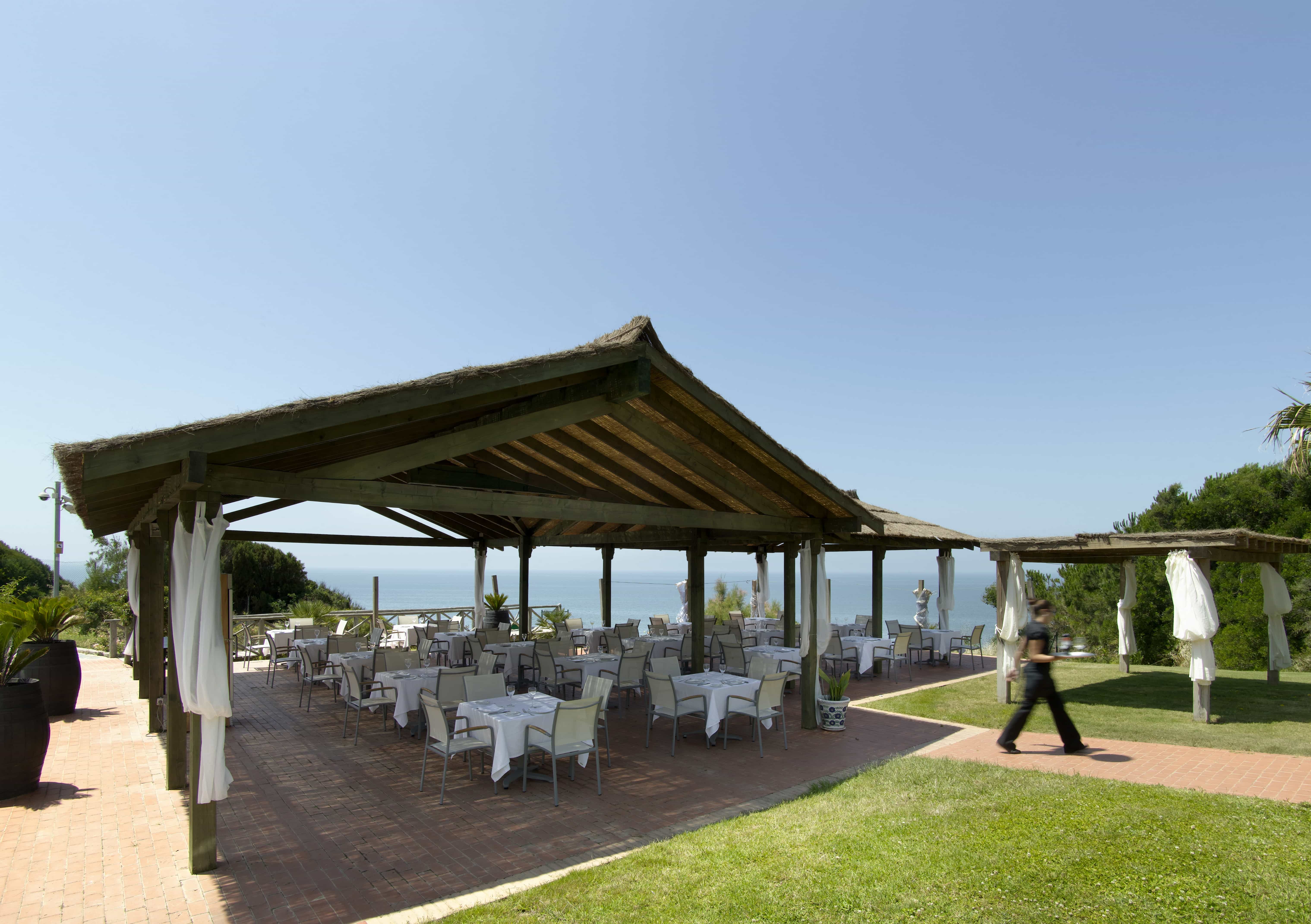 Terraza exterior cubierta del Restaurante La Zalema del Atlántico del Parador de Mazagón con vistas al mar