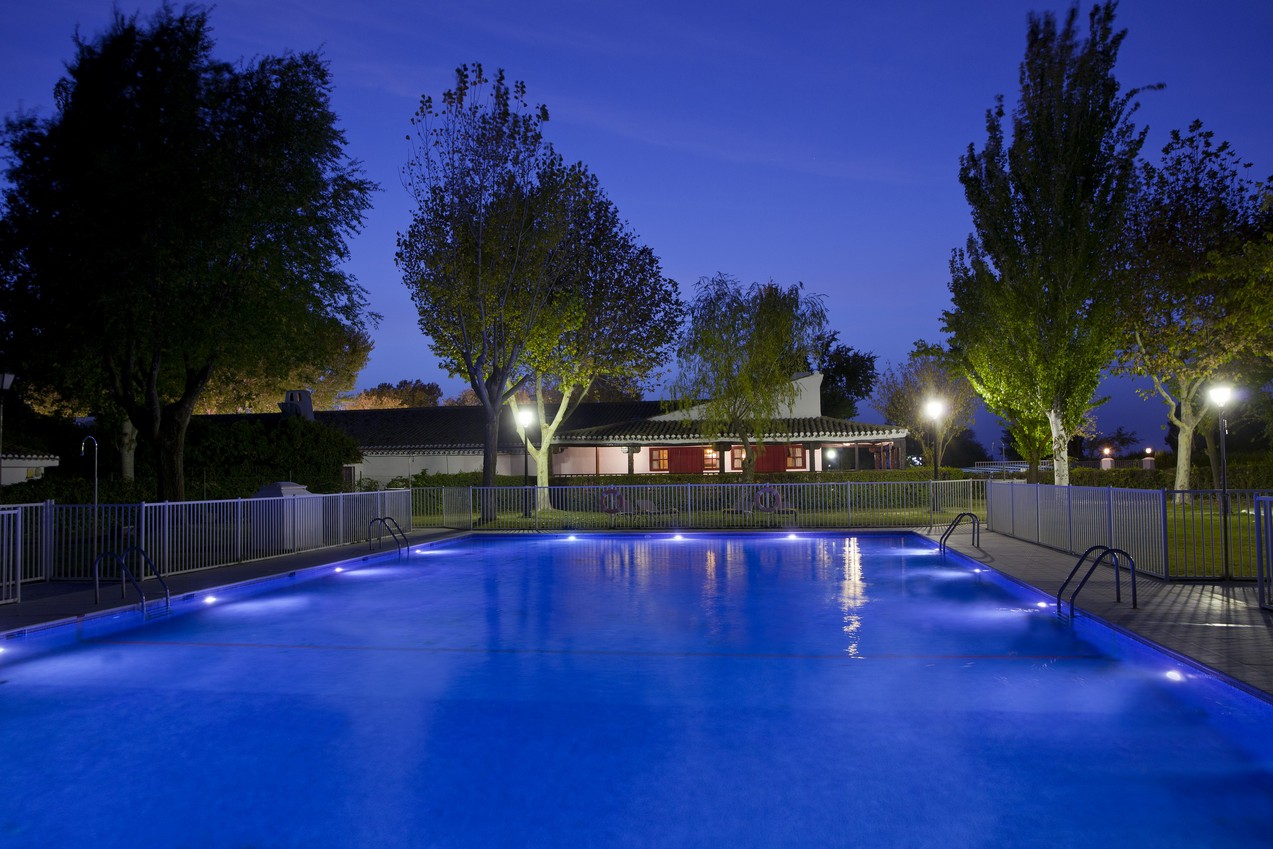 Piscina exterior del Parador de Albacete iluminada en la noche