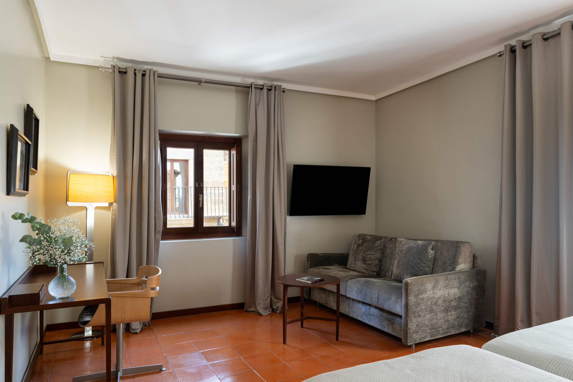 Habitación estándar con dos camas y sofá del Parador de Cáceres
