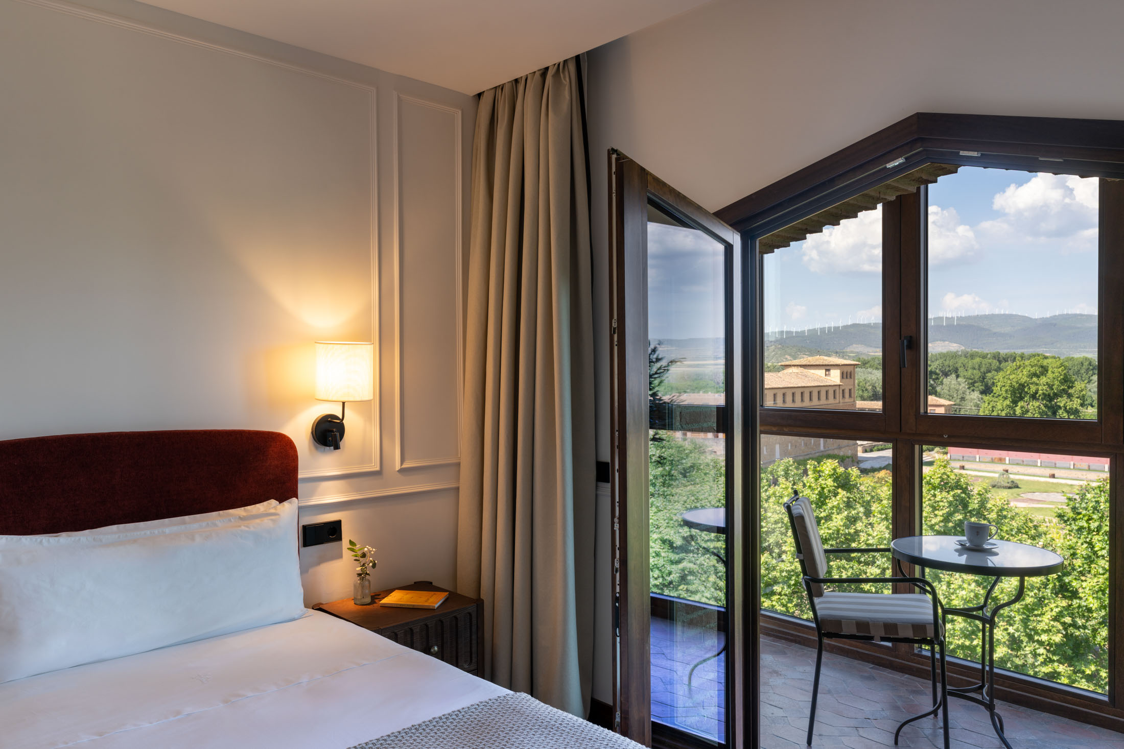 Detalle de cama, escritorio y televisor en habitación estándar del Parador de Olite-Erriberri