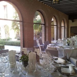 Salón de banquetes con grandes ventanales al patio interior del Parador de Chinchón