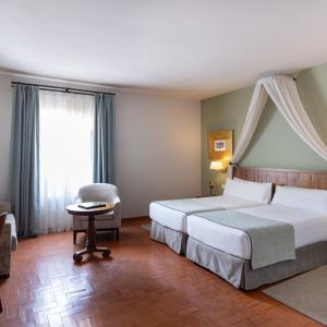 Habitación estándar con dos camas y sofá en el Parador de Trujillo