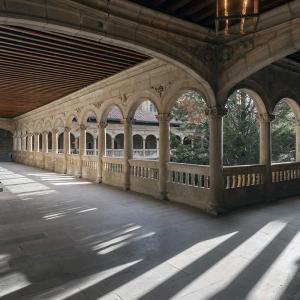 Amplio claustro superior con techos de madera del Parador de León iluminado por el sol al atardecer
