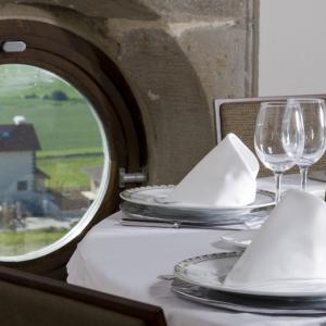 Mesa al lado de una ventana de ojo de buey en el restaurante del Parador de Argómaniz  