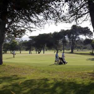 Un grupo de golfistas camina hacia su próximo hoyo en el campo de golf del Parador de Málaga Gibralfaro