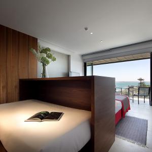 Zona de lectura en habitación de matrimonio y gran balcón al mar del Parador de Cádiz 