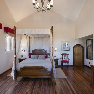 Cama con dosel y suelos de madera en habitación del Parador de Las Cañadas del Teide