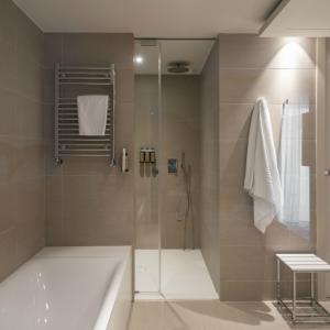 Bañera de hidromasaje, ducha a ras de suelo y secador de toallas en el baño de una junior suite del Parador de Aiguablava