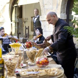 Cortador de jamón en un banquete del Parador de Cangas de Onís, con dos violinistas al fondo