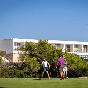 Tres golfistas practican en un green del campo de golf del Parador de El Saler