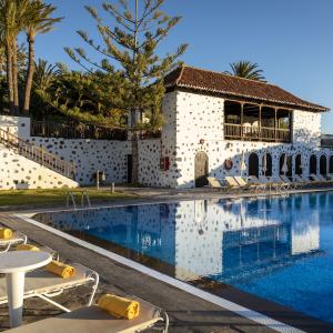 Tumbonas en la piscina del Parador de La Gomera con el hotel al fondo