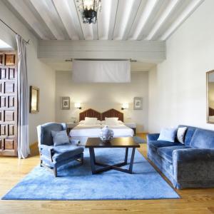 Habitación con sofá, tresillo, espejo y gran ventanal en el Parador de Zamora