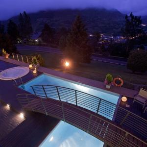 Jacuzzi exterior, piscina, terraza y solarium en el SPA &amp; Wellness del Parador de Vielha iluminados en la noche