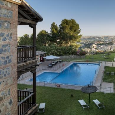 Vista de la piscina del Parador de Toledo desde las habitaciones del Parador con la ciudad de Toledo al fondo
