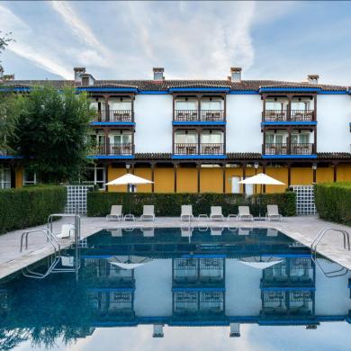 Vista de la piscina del Parador de Manzanares con el edificio del Parador al fondo