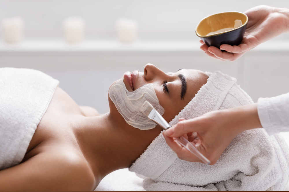 Imagen decorativa de una mujer recibiendo un tratamiento facial sobre una camilla